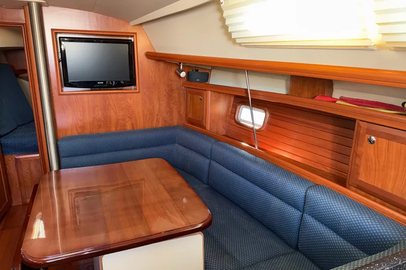 Slide: The Image of Interior of 2011 Hunter 39 sailboat with wood finish and blue upholstered seating. - 15