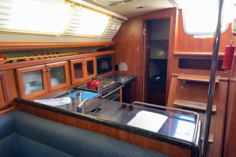 Slide: The Image of Interior of 2011 Hunter 39 sailboat with modern kitchen and wooden cabinetry. - 21
