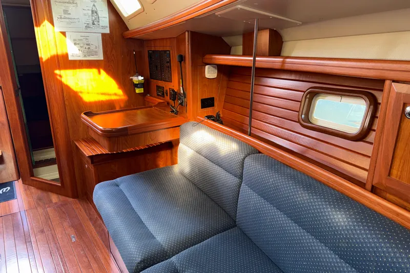 Slide: The Image of Interior of 2011 Hunter 39 sailboat with wooden paneling and blue cushioned seating. - 22