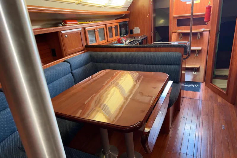 Slide: The Image of Interior of a 2011 Hunter 39 yacht with polished wood table and blue seating. - 23