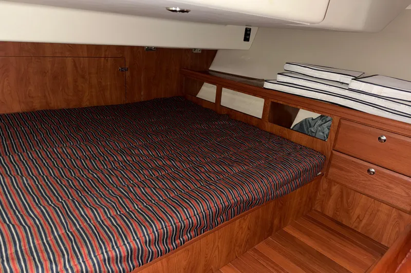 Slide: The Image of Cozy cabin interior of 2011 Hunter 39 sailboat with striped bedding and wooden finish. - 27