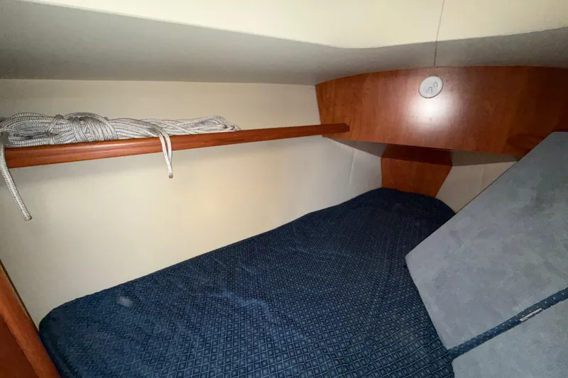 Slide: The Image of Cozy cabin interior of 2011 Hunter 39 sailboat with wooden shelf and blue bedding. - 29