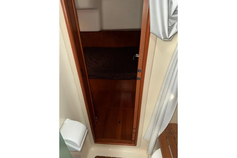 Slide: The Image of Interior cabin view of a 2011 Hunter 39 sailboat, featuring wooden door and cozy sleeping area. - 38