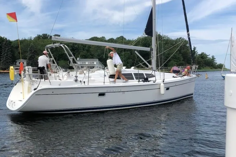 Slide: The Image of 2011 Hunter 39 sailboat on water with crew, under a clear sky. - 5