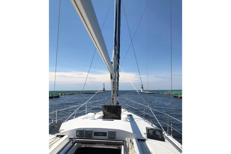 Slide: The Image of Sailing on a 2011 Hunter 39 yacht, approaching a lighthouse under clear blue skies. - 6