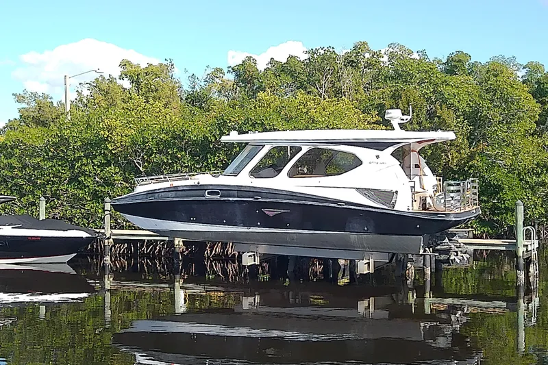 Slide: The Image of 2019 Floe Craft 3950C Aquafina boat docked near lush greenery. - 2