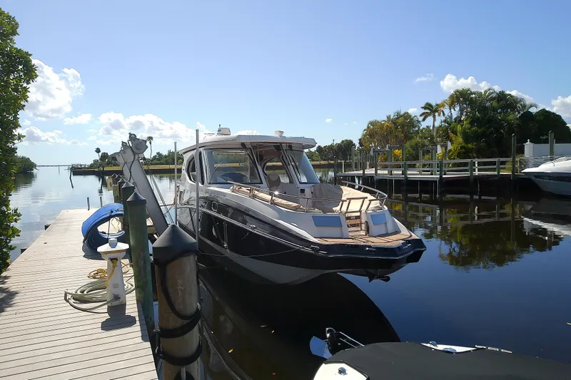 Slide: The Image of 2019 Floe Craft 3950C Aquafina boat docked on a sunny day, surrounded by lush greenery. - 6