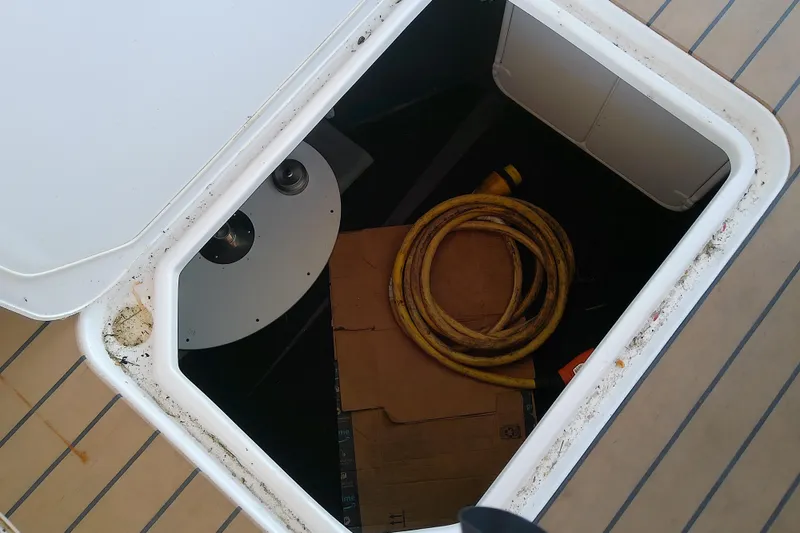 Slide: The Image of Open storage compartment on 2019 Floe Craft 3950C Aquafina boat with coiled yellow hose. - 72
