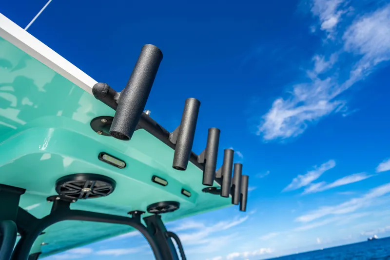 Slide: The Image of 2026 Reef Runner 340 boat with rod holders against a clear blue sky. - 18