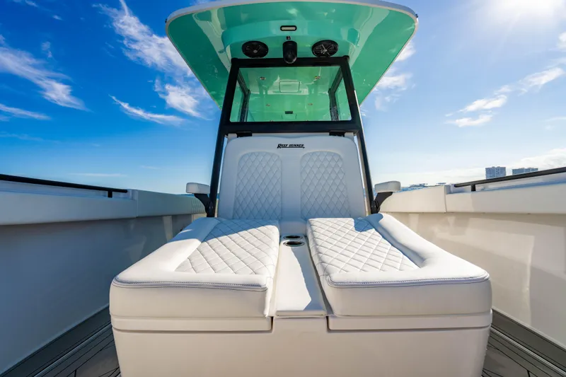 Slide: The Image of 2026 Reef Runner 340 boat interior with luxurious seating under clear blue sky. - 23