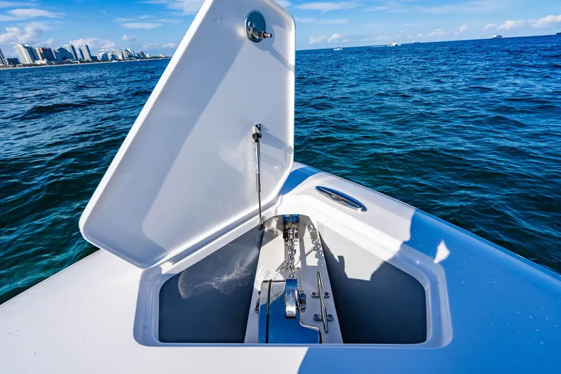 Slide: The Image of Open anchor compartment on 2026 Reef Runner 340 boat, with ocean and city skyline in background. - 26