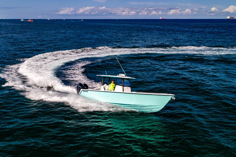 Slide: The Image of 2026 Reef Runner 340 boat making a sharp turn on open ocean waters. - 3