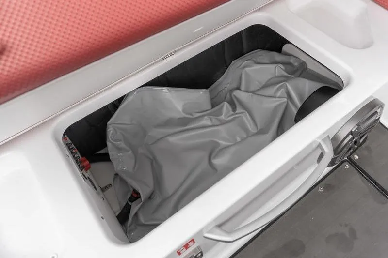 Slide: The Image of Storage compartment of 2026 Scarab 285 LX Wake boat with gray cover inside. - 23