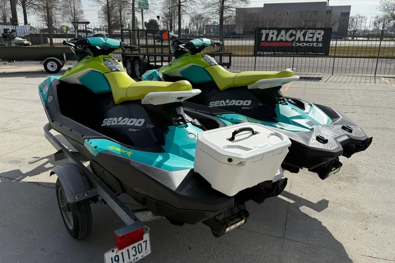 Slide: The Image of 2022 Sea-Doo Spark 3up jet skis on trailer, parked outdoors. - 4