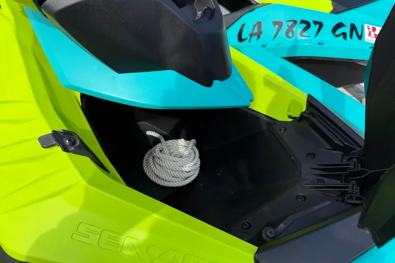 Slide: The Image of 2022 Sea-Doo Spark 3up storage compartment with rope, vibrant yellow and blue design. - 7