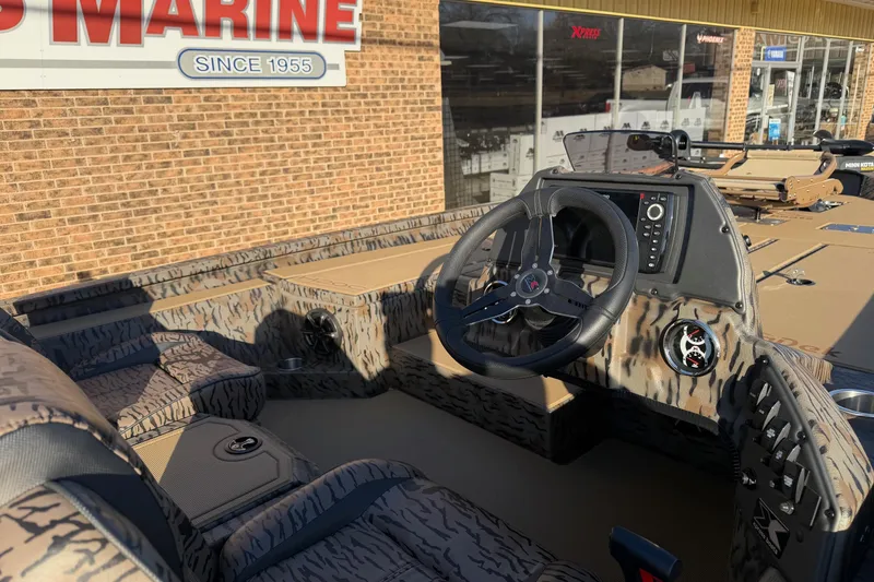 Slide: The Image of 2026 Xpress H20C Crappie boat interior with camo design and modern steering console. - 4