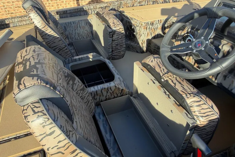 Slide: The Image of 2026 Xpress H20C Crappie boat interior with camo seats and steering wheel. - 7
