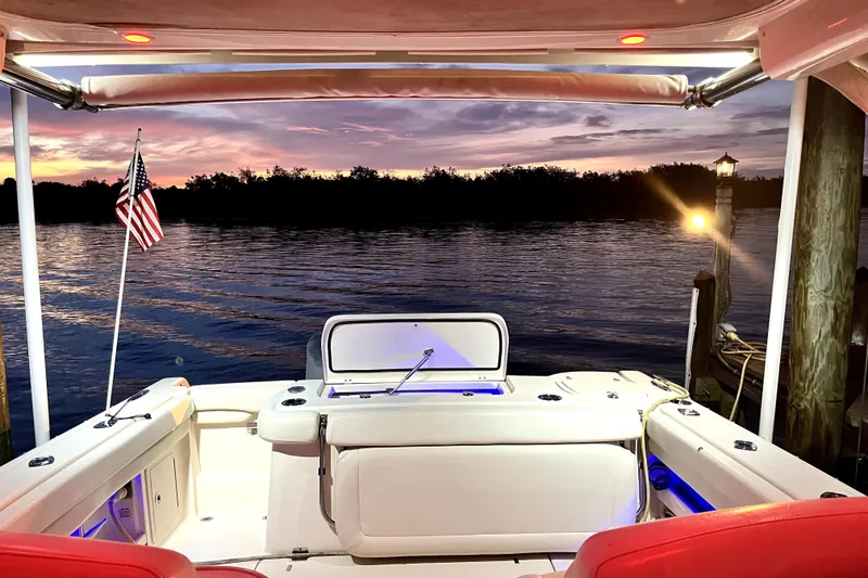 Slide: The Image of 2017 Grady-White Freedom 307 boat at sunset, docked with American flag. - 10