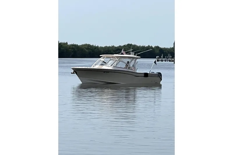 Slide: The Image of 2017 Grady-White Freedom 307 boat on calm water, with trees in the background. - 3