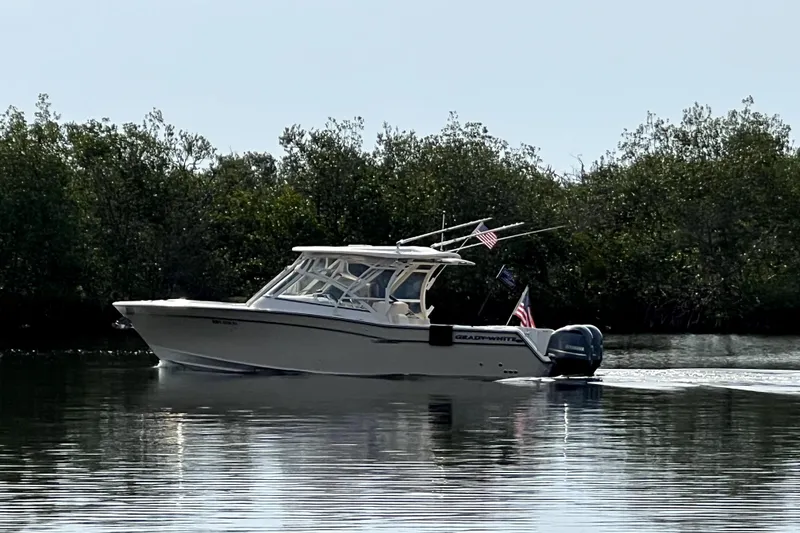 Slide: The Image of 2017 Grady-White Freedom 307 boat cruising on calm water near lush greenery. - 4