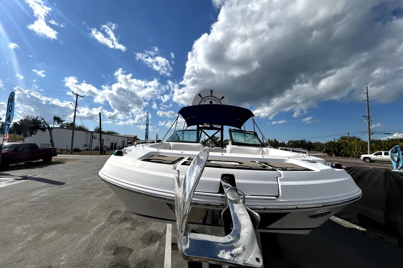 Slide: The Image of 2018 Four Winns HD240 boat with anchor, parked under a cloudy sky. - 10