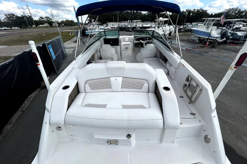 Slide: The Image of 2018 Four Winns HD240 boat with white seating and blue canopy, docked at marina. - 12