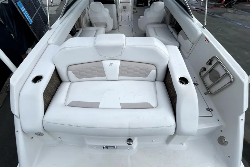 Slide: The Image of 2018 Four Winns HD240 boat interior with white seating and cup holders. - 13