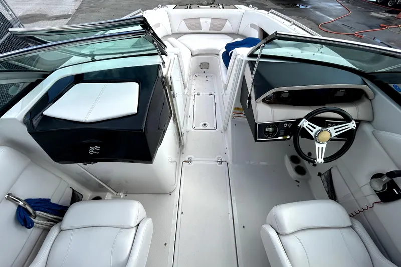 Slide: The Image of 2018 Four Winns HD240 boat interior with white seating and modern dashboard. - 18