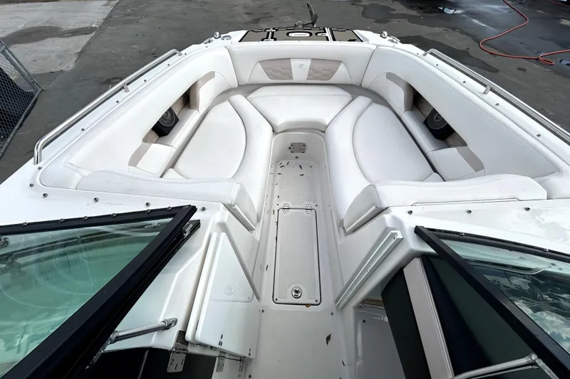 Slide: The Image of 2018 Four Winns HD240 boat interior with white seating and open windshield. - 19
