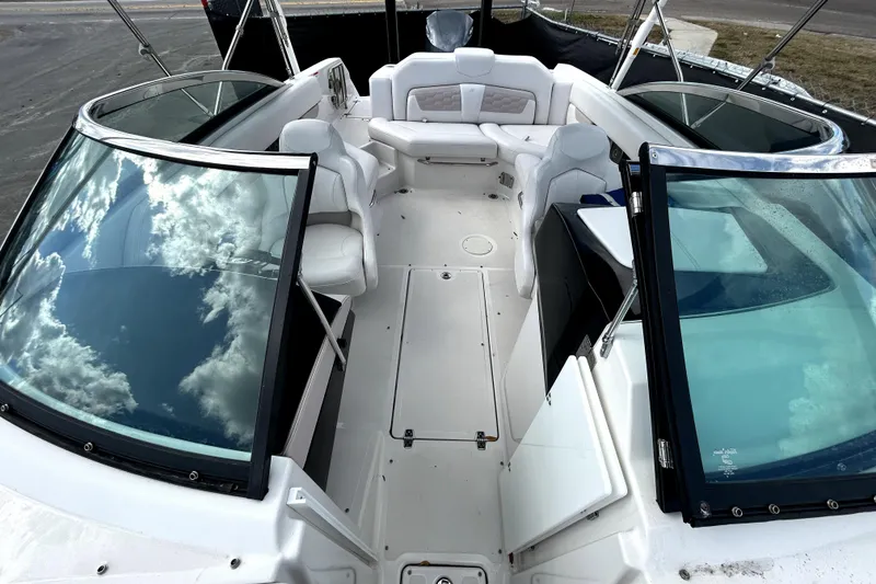 Slide: The Image of 2018 Four Winns HD240 boat interior with white seating and open windshield. - 26