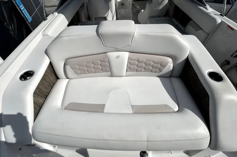 Slide: The Image of 2018 Four Winns HD240 boat interior with white cushioned seating and cup holders. - 35