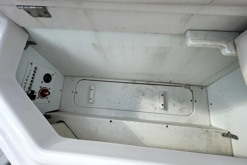 Slide: The Image of Storage compartment of a 2018 Four Winns HD240 boat, featuring control panel and latch. - 48