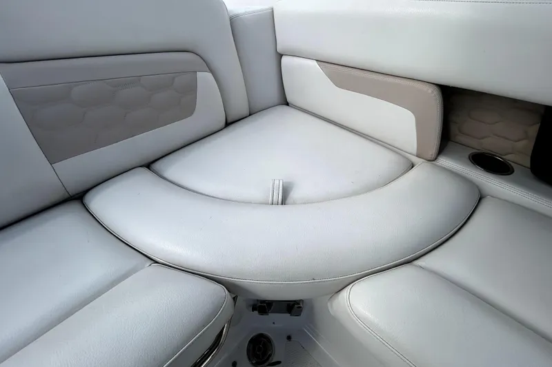 Slide: The Image of 2018 Four Winns HD240 boat interior seating with white and beige upholstery. - 50