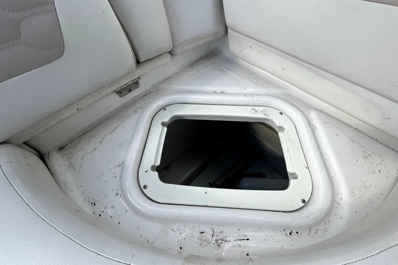 Slide: The Image of Open storage compartment on 2018 Four Winns HD240 boat with white interior. - 52