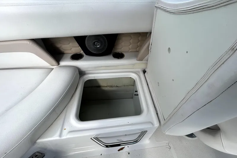 Slide: The Image of 2018 Four Winns HD240 boat interior with open storage compartment and cup holders. - 55