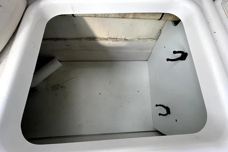 Slide: The Image of Storage compartment of a 2018 Four Winns HD240 boat, featuring hooks and a clean interior. - 56