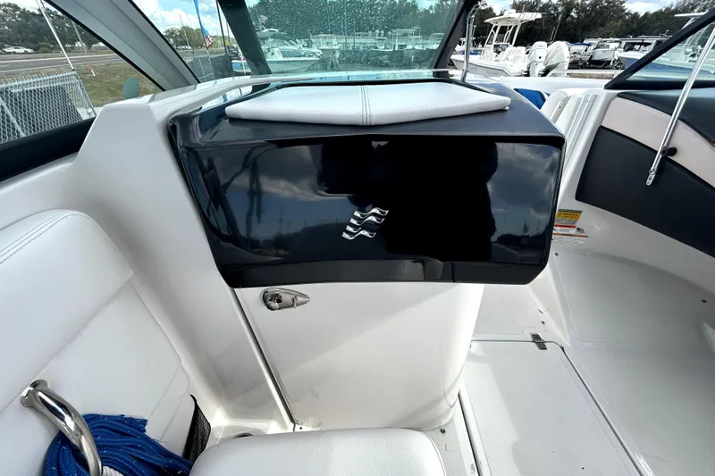 Slide: The Image of 2018 Four Winns HD240 boat interior with sleek black dashboard and white seating. - 60