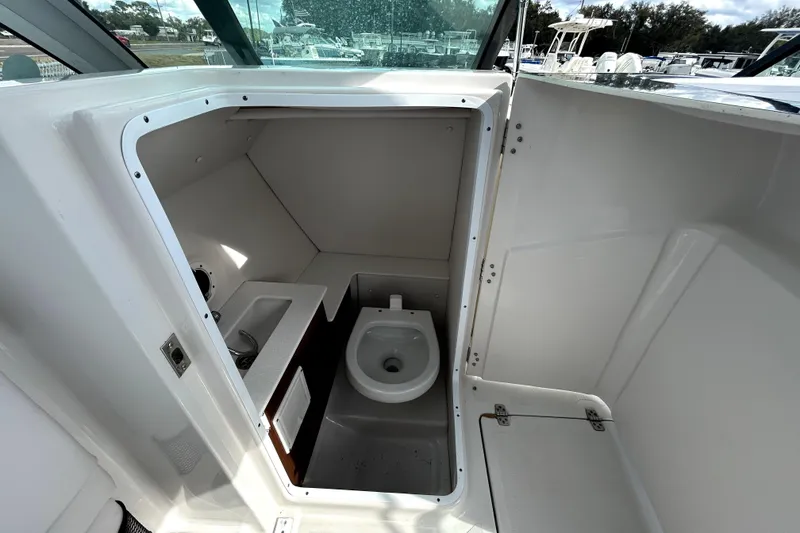 Slide: The Image of 2018 Four Winns HD240 boat interior with compact bathroom and toilet. - 61
