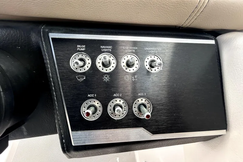 Slide: The Image of Control panel of a 2018 Four Winns HD240 boat with various switches. - 69