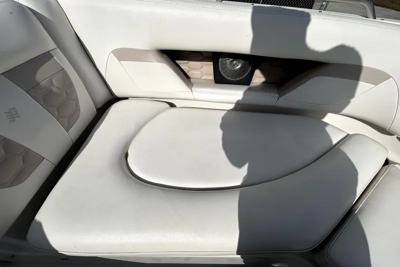 Slide: The Image of 2018 Four Winns HD240 boat interior with white cushioned seating and speaker. - 76