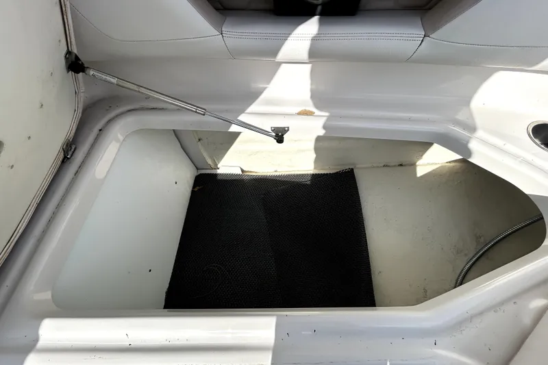Slide: The Image of Storage compartment in 2018 Four Winns HD240 boat, featuring a black mat and hydraulic lift. - 78