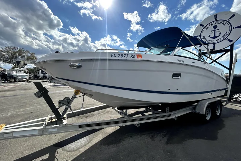Slide: The Image of 2018 Four Winns HD240 boat on trailer under a partly cloudy sky. - 8