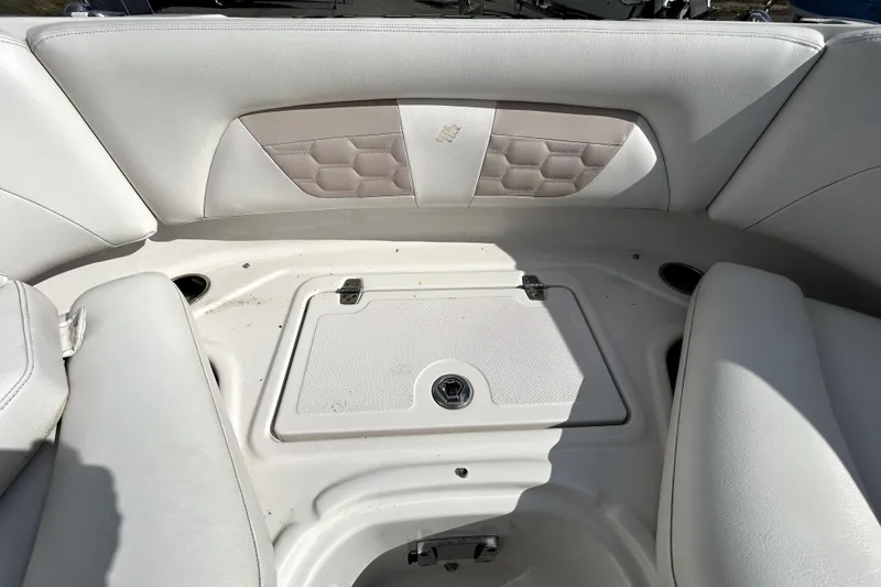 Slide: The Image of 2018 Four Winns HD240 boat interior with white cushioned seating and storage compartment. - 80