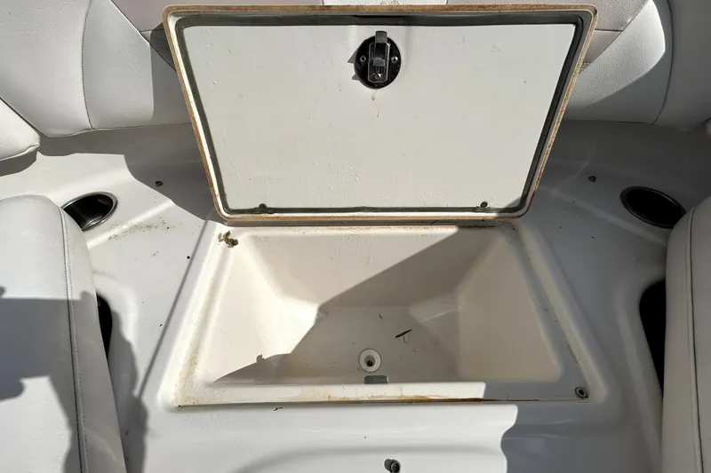 Slide: The Image of Open storage compartment on 2018 Four Winns HD240 boat, white interior. - 81