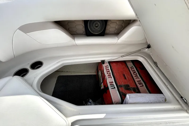 Slide: The Image of 2018 Four Winns HD240 boat storage with life jackets and cup holders. - 83
