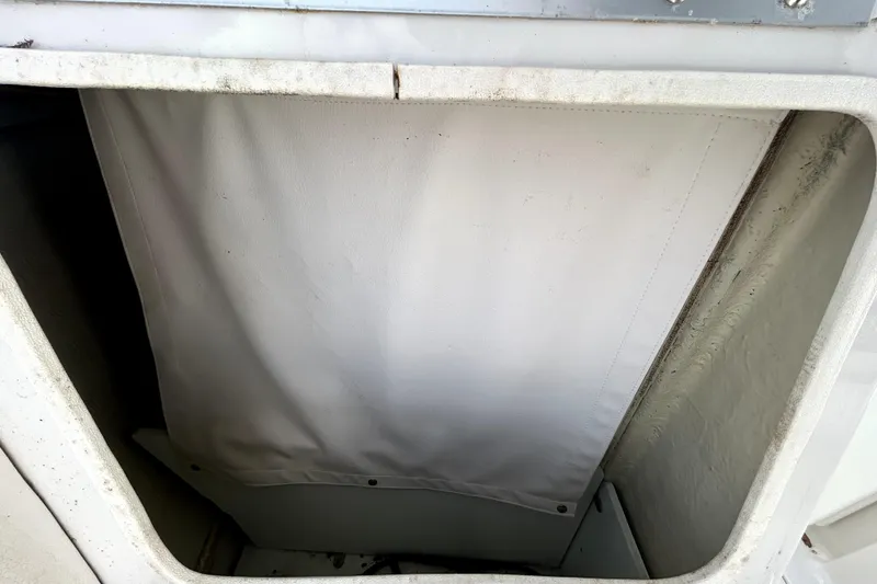 Slide: The Image of Storage compartment of 2018 Four Winns HD240 boat, featuring a white interior cover. - 87