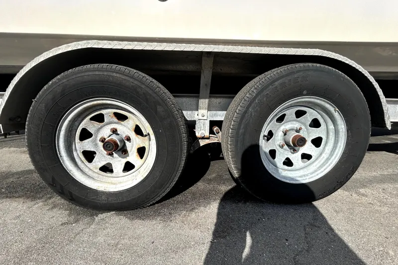 Slide: The Image of Trailer wheels of a 2018 Four Winns HD240 boat on pavement. - 89