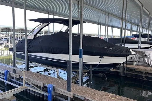 Slide: The Image of 2019 Sea Ray SLX 250 boat covered and docked in a marina. - 26