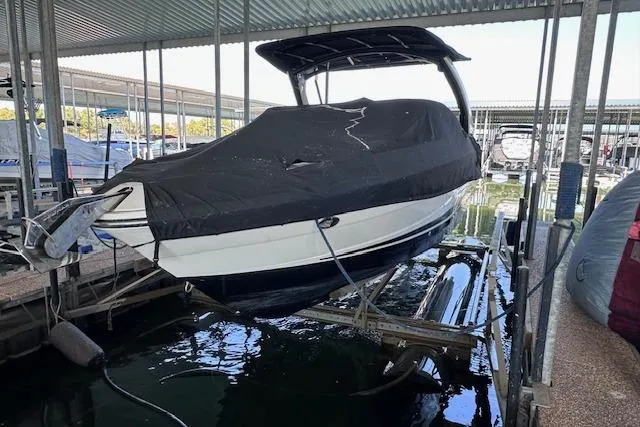 Slide: The Image of 2019 Sea Ray SLX 250 boat covered and docked in a marina. - 27