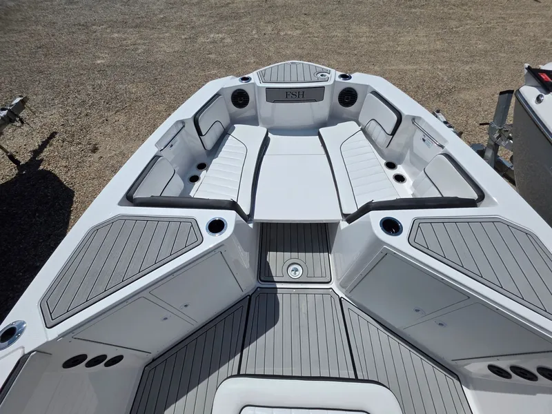 Slide: The Image of The image shows the deck of a 2026 Yamaha 222 FSH Sport E boat with gray cushions and storage compartments. - 16